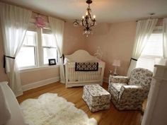 a baby's room with a crib, chair, and ottoman in it