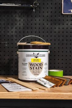 a can of wood stain sitting on top of a table next to some pieces of wood