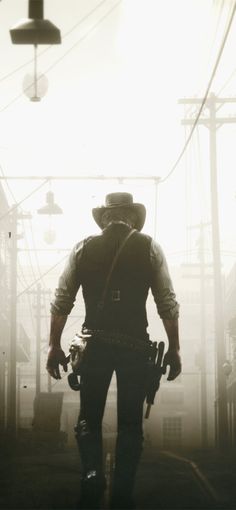 a man walking down a street next to power lines and telephone poles in the fog