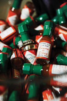 many small bottles of condiments with labels on them are stacked in a pile