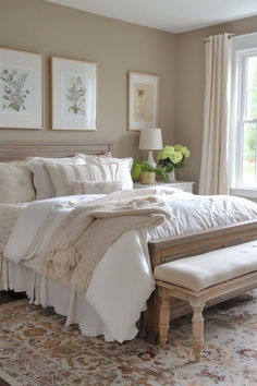 a white bed sitting in a bedroom next to a window covered in blankets and pillows