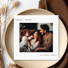 a family photo on a plate next to some dried flowers and plants, with the words merry - bright above it