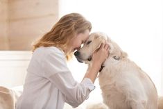 a woman petting a dog on the nose