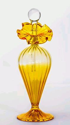 a yellow glass vase sitting on top of a white table