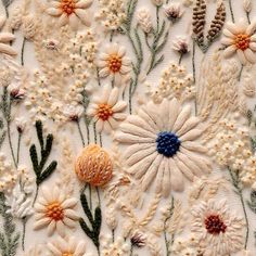 an embroidered fabric with flowers and plants on it's side, in the middle