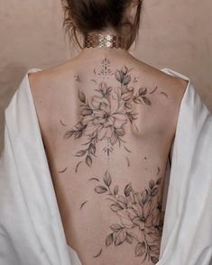 the back of a woman's neck with flowers on it