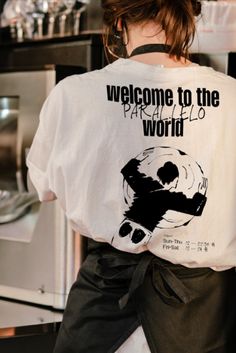 a woman wearing a t - shirt that says welcome to the world