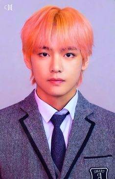 a young man with pink hair wearing a suit and tie, looking at the camera