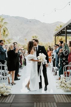 a newly married couple kissing in front of an outdoor ceremony