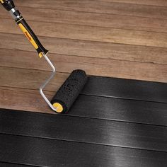 a mop is laying on top of a wooden floor next to a black mat