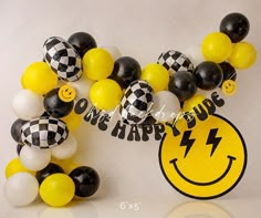 some balloons are arranged in the shape of a smiley face and one happy dude sign