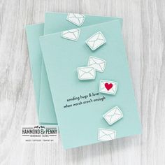 two greeting cards with envelopes on top of each one and a red heart in the middle