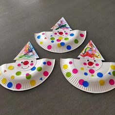 three paper plates with colorful polka dot designs on them and one has a clown face