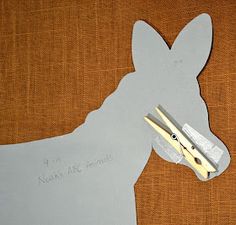 a paper cut out of a dog with scissors in it's mouth and some writing on the side