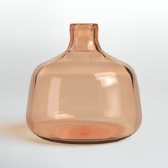 a brown glass vase sitting on top of a white table