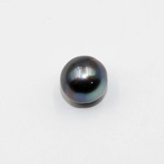 a black pearl is shown on a white surface with no other object in the background