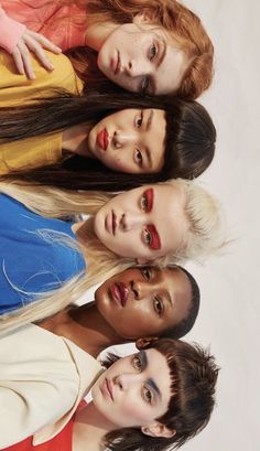 four young women are standing in a row