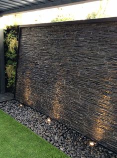 an outdoor water feature with rocks and grass