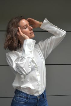 A dressier take on a pleated clean collar blouse. This modern button-down features tuxedo style pleating on the bib and cuffs with a clean stand-up collar. Wear with elegant trousers or dressed down with jeans. 100% cotton Dress Shirt With Jeans, Wide Cuff Jeans, Elegant Trousers, Shirt With Jeans, Slouchy Jeans, Tuxedo Style, Feminine Top, Cuffed Jeans, Muscle Shirts