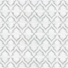 a white tile wall with an intricate design