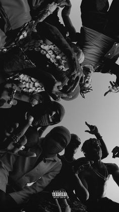 a group of people standing next to each other with their hands in the air and looking up