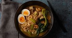 a bowl of ramen with an egg on top and chopsticks next to it