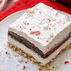 a piece of cake with white frosting and candy canes on it sitting on a plate