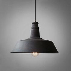 an industrial style light fixture hanging from a gray ceiling with a white wall in the background