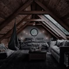 an attic bedroom with wooden walls and exposed ceiling, large bed in the corner, two couches on either side