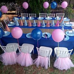 a blue table topped with pink tulle skirted chairs and plates covered in balloons