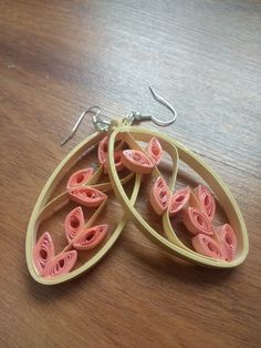 two pairs of pink and yellow earrings on a wooden table with silver earwires