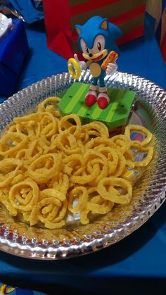 a silver plate topped with lots of food on top of a blue cloth covered table