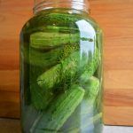 a jar filled with pickles sitting on top of a table