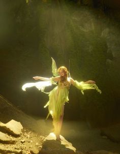 a woman dressed as a fairy standing in the sun