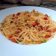 a white plate topped with spaghetti and vegetables