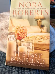 the last boyfriend by nora roberts is on top of a bed next to a teddy bear