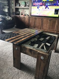 a coffee table made out of pallet wood with a video game on the screen