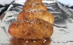 three baked potatoes sitting on top of aluminum foil