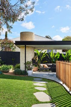 an outdoor living area with green grass and wooden fence