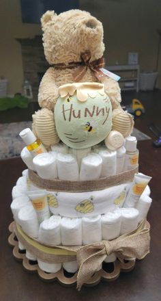 a teddy bear sitting on top of a diaper cake