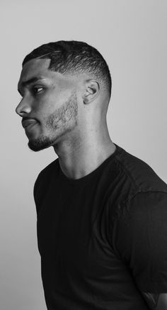 a black and white photo of a man with a goatee on his head looking off to the side