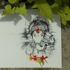 there is a drawing of an elephant on the paper next to some flowers and leaves