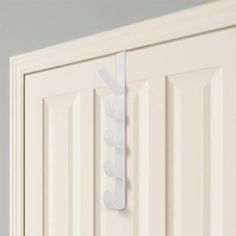 a white door handle on the side of a white door with an arrow shaped design