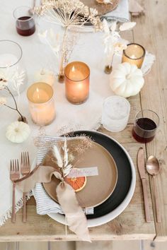 the table is set with plates, silverware and candles