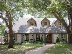 a house with a red pin on the front door and trees in front of it