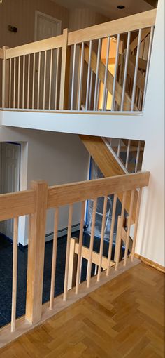 an empty room with wooden stairs and hard wood flooring on the other side of the staircase