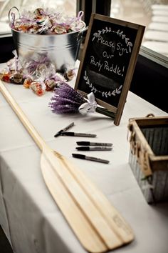 the table is set up for an outdoor party with chalkboard and wooden utensils