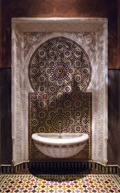 a bathtub in the middle of a room with an intricate tile work on it