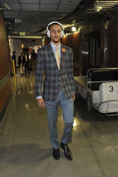 a man in a suit and headphones walking through an airport