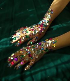 a woman's hands with colorful jewels on them